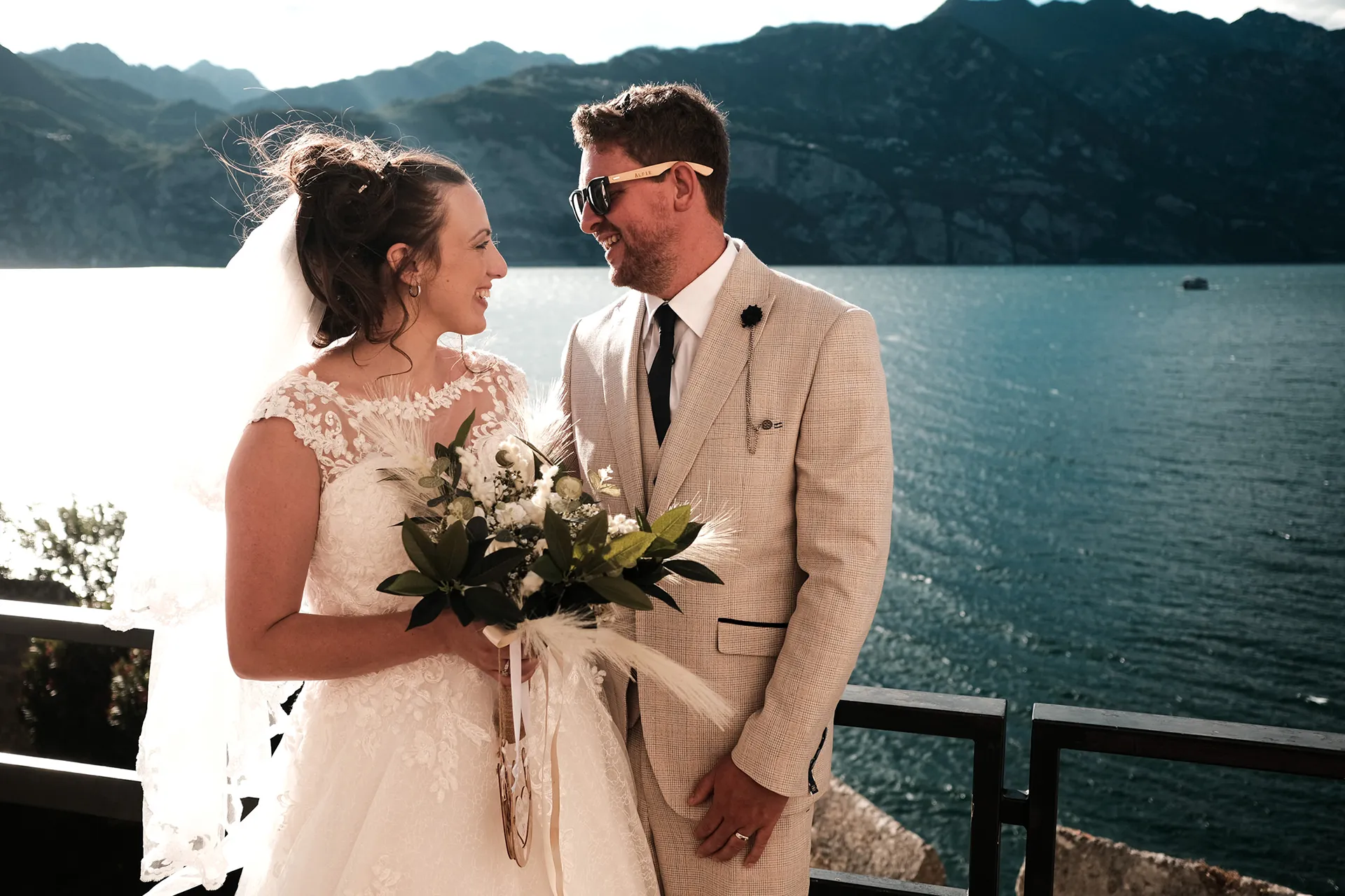 Casal diante do lago e das montanhas de Malcesine